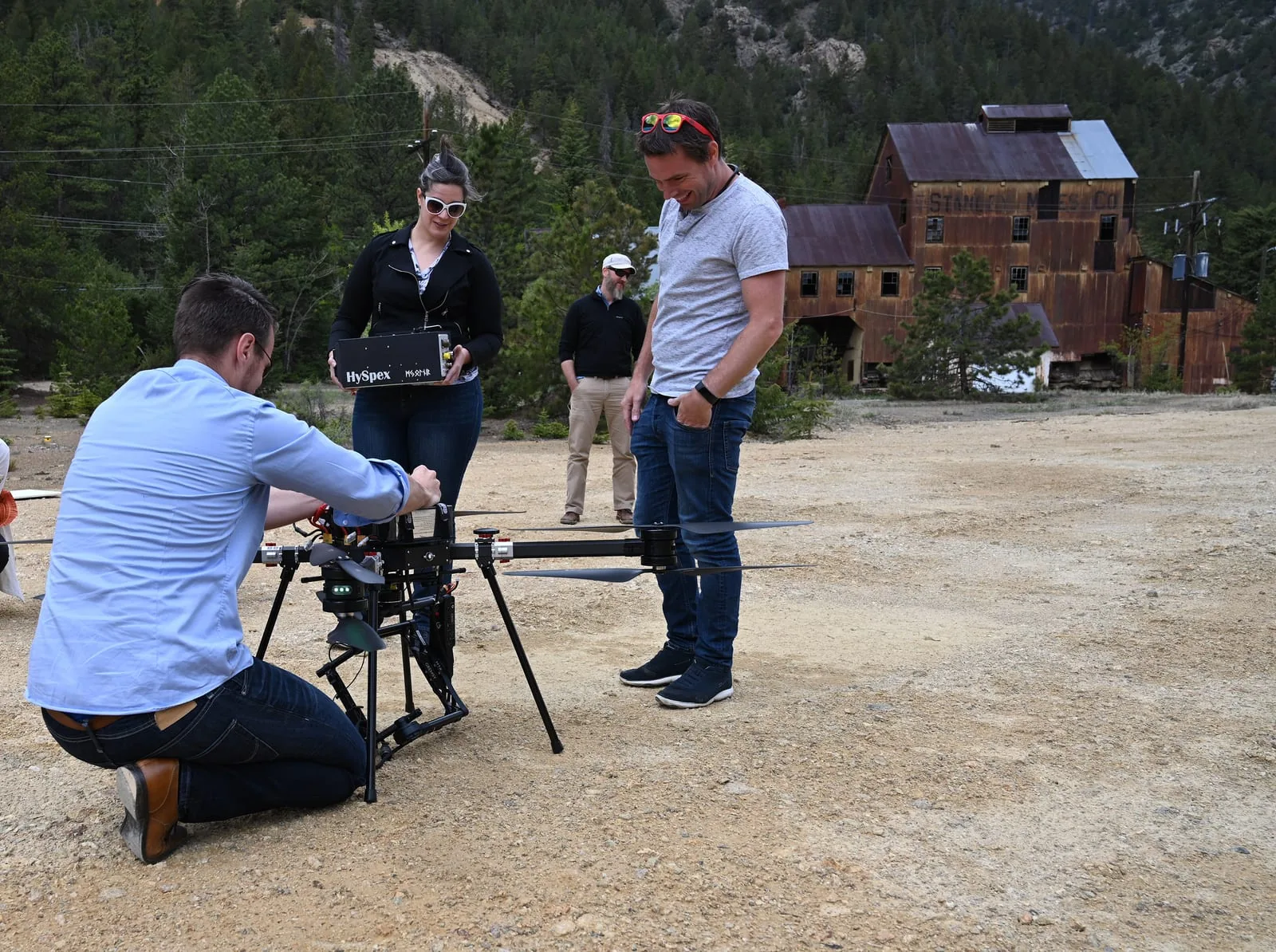 Participants prepare a large multirotor and hyperspectral imaging equipment outdoors.