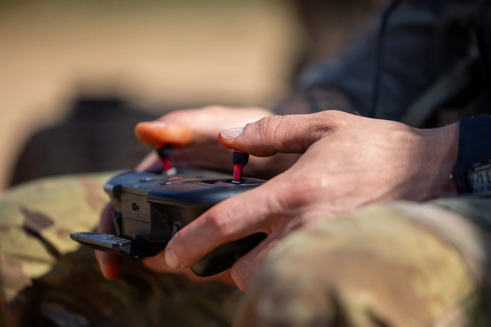 An instructor operates an unmanned aircraft controller during a training event