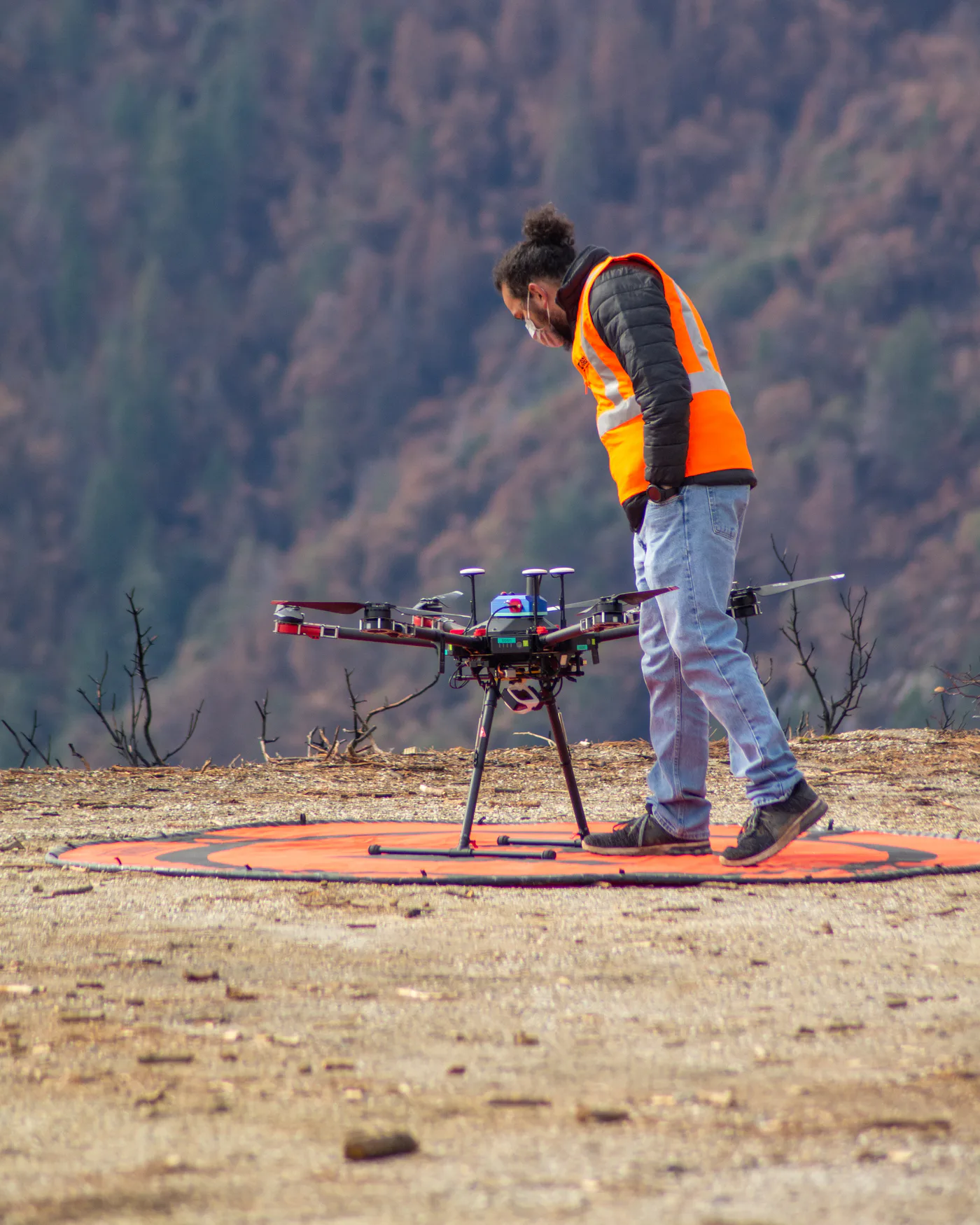 USGS staff member Isaac Anderson inspecting a drone before a photogrammetry mission in Tahoe National Forest.